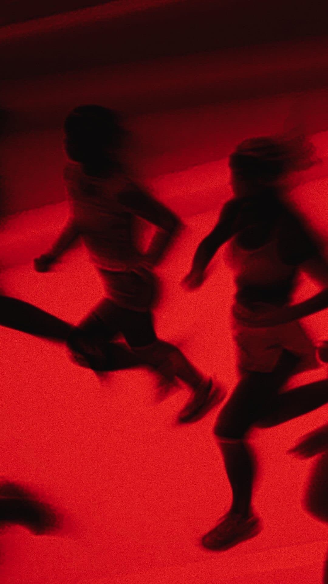 Runners in motion blur, lit entirely in infrared red